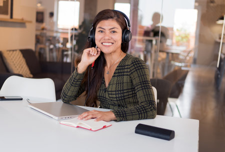 Smiling Asian woman in headset working as consultantの写真素材