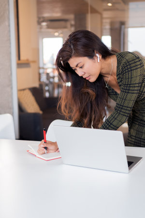 Concentrated female worker writing in plannerの写真素材