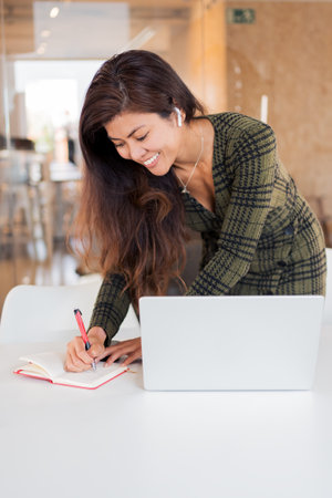 Happy woman with organizer and laptopの写真素材