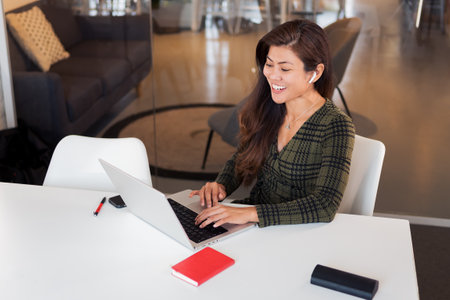 Laughing lady with netbook in workspaceの写真素材