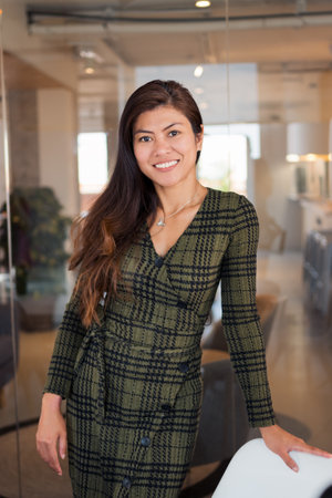 Smiling woman standing in room of office buildingの写真素材