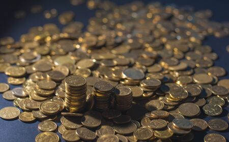Banking and money trading. Golden metal coins stacked in different combinations on dark blue blurred background. Serbian metal coin, copy spaceの写真素材