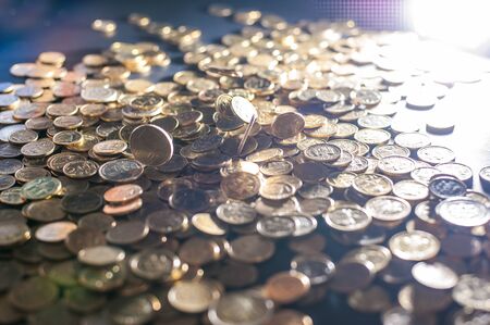 Banking and money trading. Metal coins stacked in different combinations on dark blue blurred background and lens flare. Serbian metal coins, copy space. Close up of metal money. Business conceptの写真素材