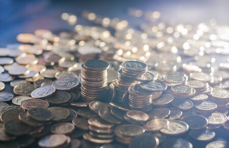 Banking and money trading. Metal coins stacked in different combinations on dark blue blurred background and lens flare. Serbian metal coins, copy space. Close up of metal money. Business conceptの写真素材