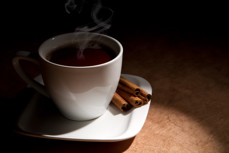 cup of coffee with cinnamon on a old paper background.の写真素材