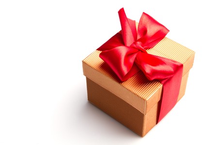 gold gift with the red ribbon isolated on white backgroundの写真素材