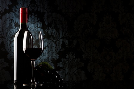 bottle with red wine and glass on a old stoneの写真素材