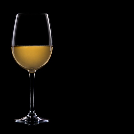 A glass of white wine, isolated on a black  background.の写真素材