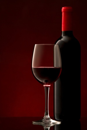 bottle with red wine and glass and grapesの写真素材