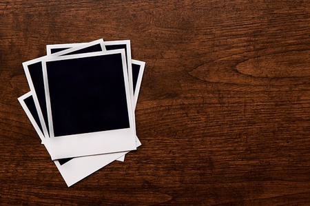 Empty instant photos on wooden table backgroundの写真素材