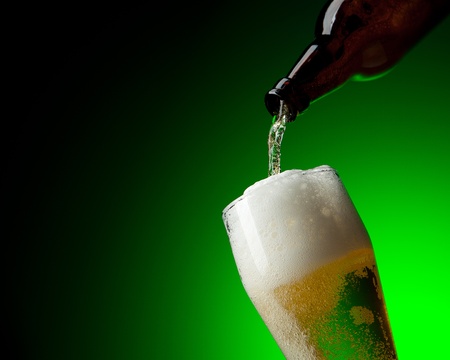 beer and bootle in dinamic on a green backgroundの写真素材