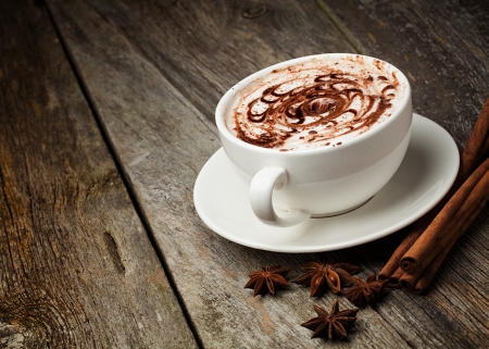 A cup of coffee or hot chocolate and female feet with socks on.. A cup of coffee or hot chocolate and female feet with socks on..