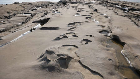 Deepening relief in the form of craters on limestone and rock near the sea
