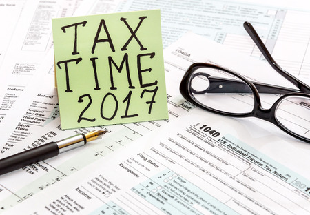 The inscription "Tax time 2017 " on the sticker, pen and glasses on tax forms.の写真素材