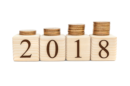 Stacks of coins on wooden cubes with numbers 2018. の写真素材