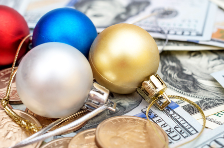 Christmas balls with coins on dollar bills background.の写真素材