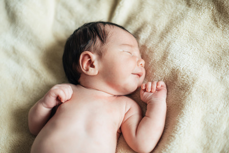 Cute child baby boy with yellow tulips in a waistcoat and a cap. Mothers day, spring concept.の写真素材