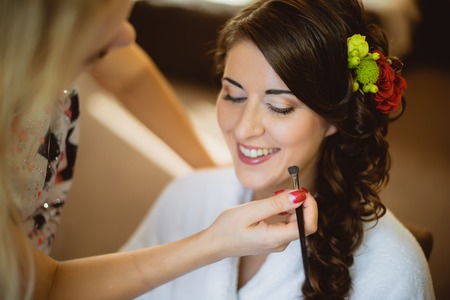 Stylist makes makeup bride on the wedding day in the roomの写真素材
