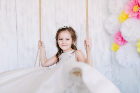 girl in studio is riding on swingの写真素材