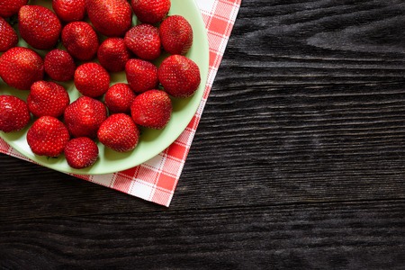 Strawberries in a plate on a green towelの写真素材
