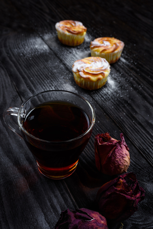 Black tea in a glass cup with cupcakesの写真素材