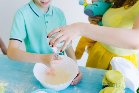Mother and son in kitchen making doughの写真素材