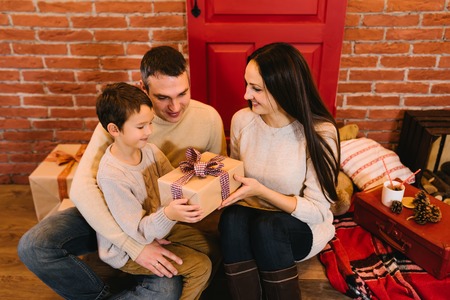 Young parents give his son a Christmas presentの写真素材