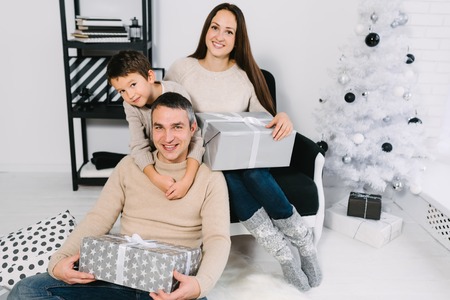 Family exchanging Christmas gifts near a Christmas tree