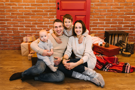 Family exchanging Christmas gifts near a Christmas treeの写真素材
