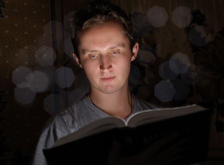 Man reading book in darknessの写真素材