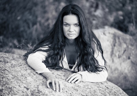 Beautiful woman recline on stoneの写真素材