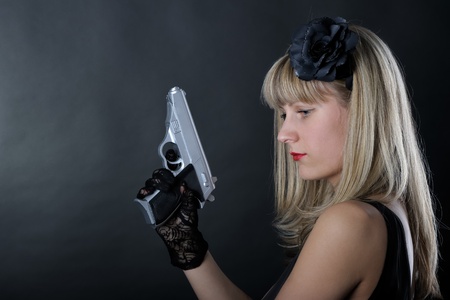 Gangster woman with pistol in blackの写真素材