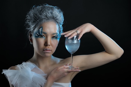 Portrait of woman with creative makeup and wineglass in her handsの写真素材