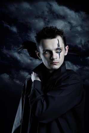 Spooky man with crow on his shoulderの写真素材