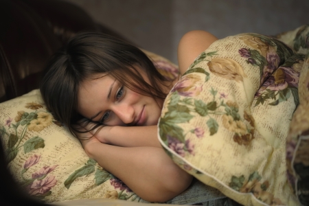 Young beautiful woman sleeping on bed in bedroomの写真素材