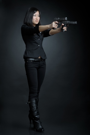 Asian woman with a pistolの写真素材
