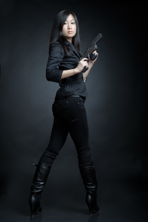 Asian woman with a pistolの写真素材