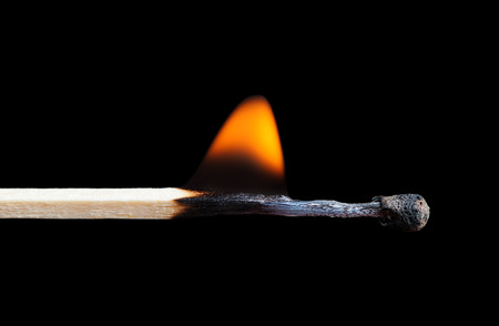 Burning match on black backgroundの写真素材