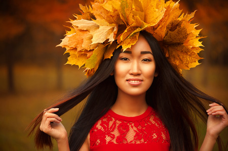 Asian woman with wreath of maple leavesの写真素材