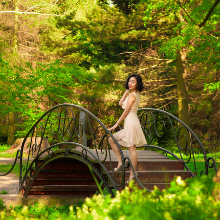 Woman on bridge in parkの写真素材