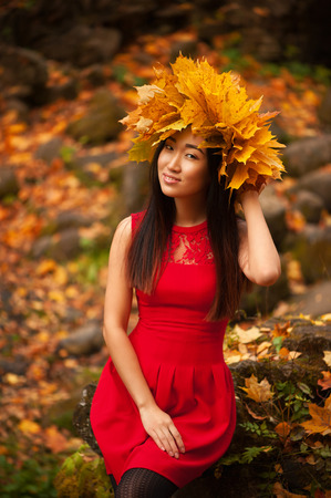 Asian woman with wreath of maple leavesの写真素材