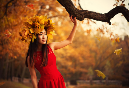 Asian woman with wreath of maple leavesの写真素材