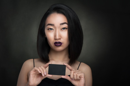 Asian woman hold black empty cardの写真素材