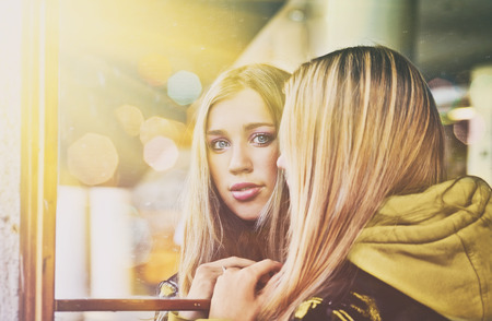 Blond girl stand near mirrorの写真素材