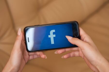 Saint-Petersburg / Russian Federation - 27 March 2019: Female hand with manicure holding cellphone with Facebookのeditorial素材