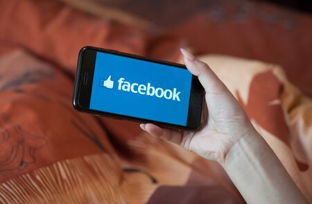 Saint-Petersburg / Russian Federation - 27 March 2019: Female hand with manicure holding cellphone with Facebookのeditorial素材