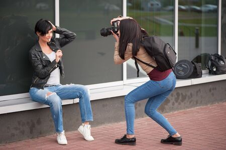 Saint-Petersburg / Russian Federation - 24 July 2017: Young woman photographer doing a photoshoot with model outdoorsのeditorial素材
