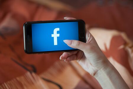 Saint-Petersburg / Russian Federation - 27 March 2019: Female hand with manicure holding cellphone with Facebookのeditorial素材