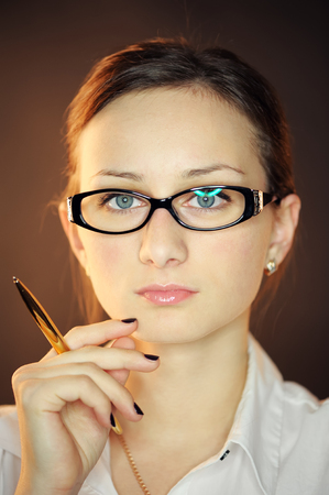 Portrait of woman in glasses with a penの写真素材