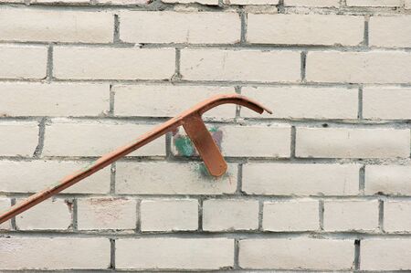 Old railing on painted beige weathered stained brick wall